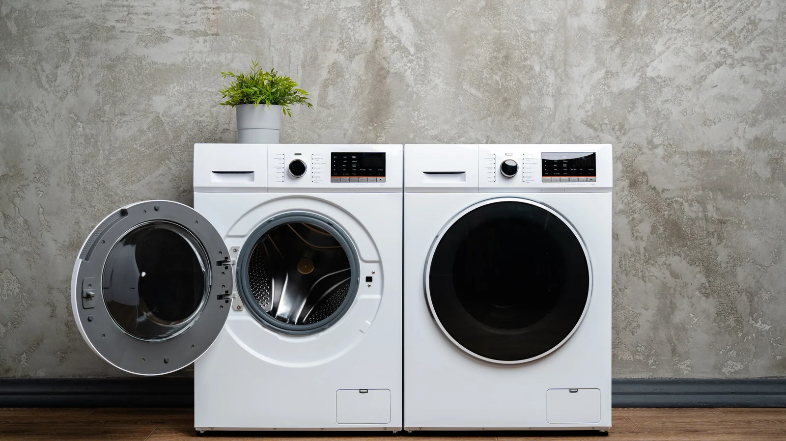A modern white front load washing machine in a laundry room